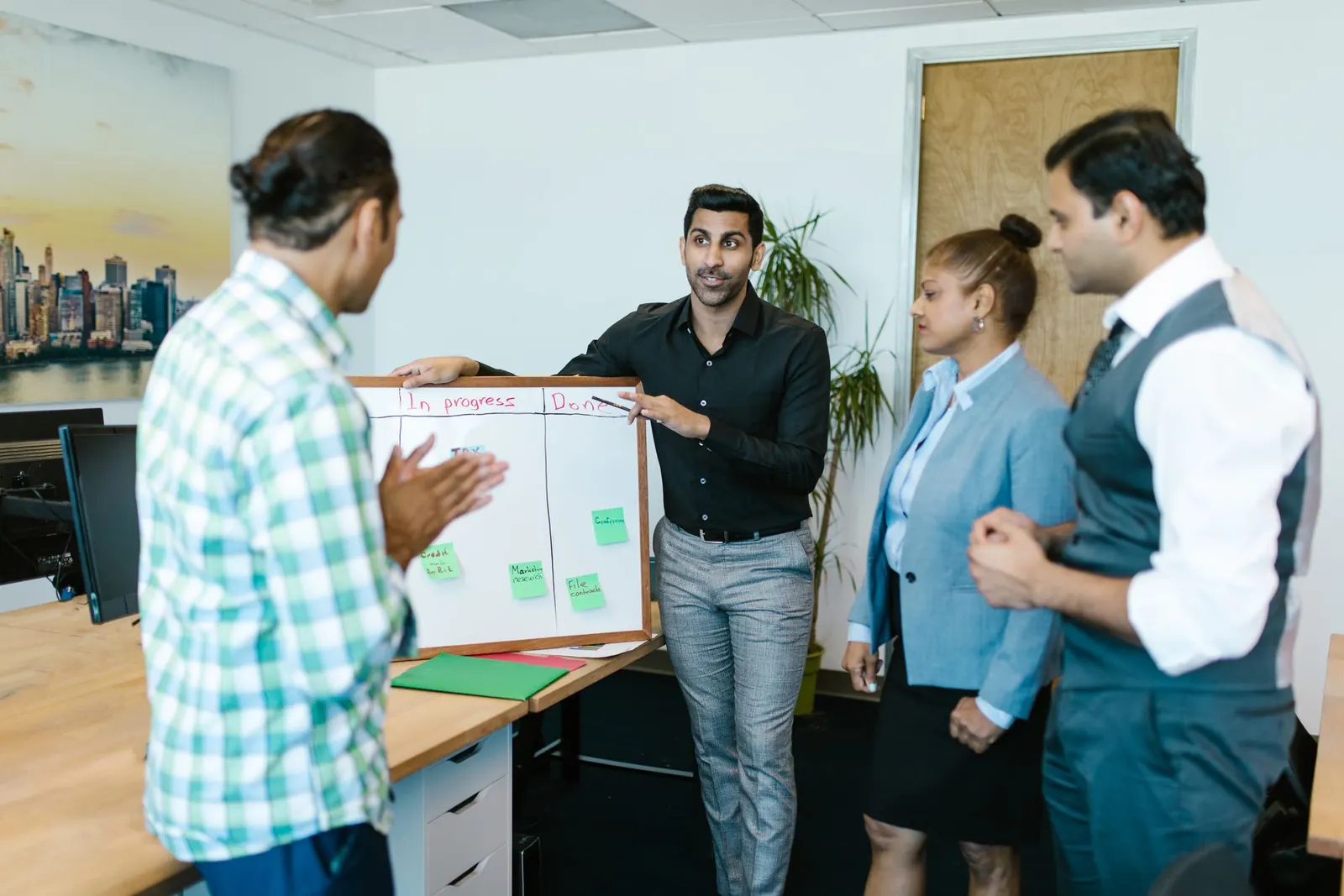 Colleagues gathered around a whiteboard during a team meeting