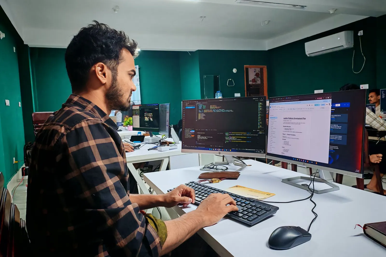 A software engineer working across three monitors