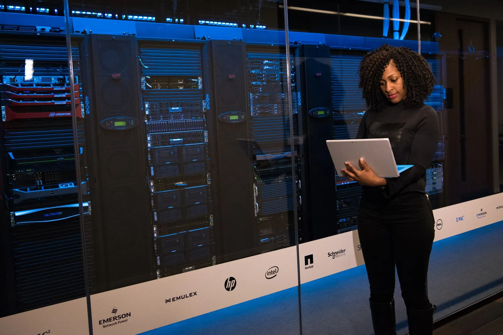 An engineer with a laptop in a server room