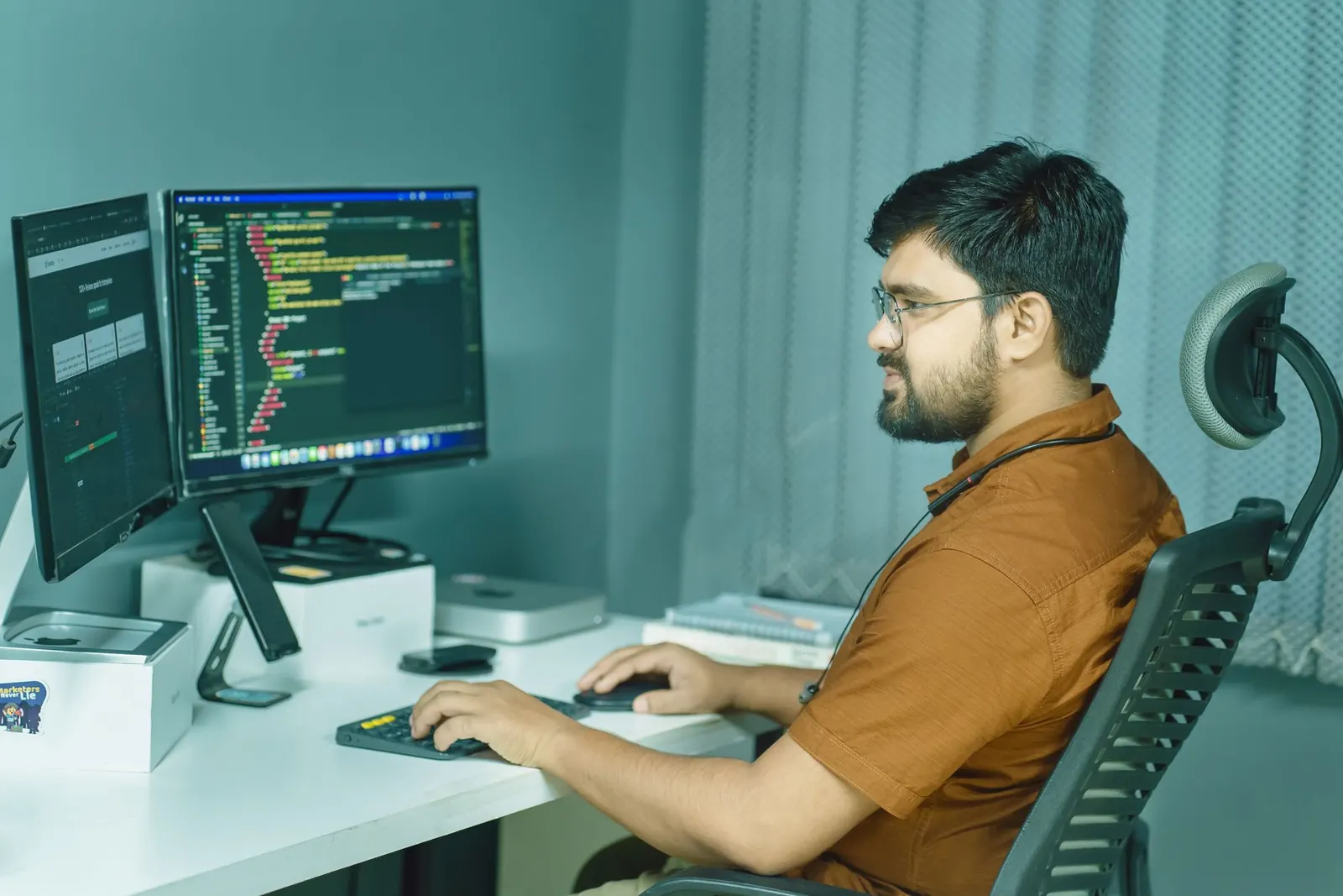 A developer writing code across two monitors